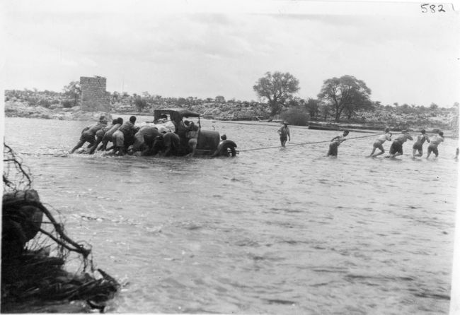 Motor car being towed away across Omaruru river in flood
