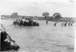 Motor car being towed away across Omaruru river in flood